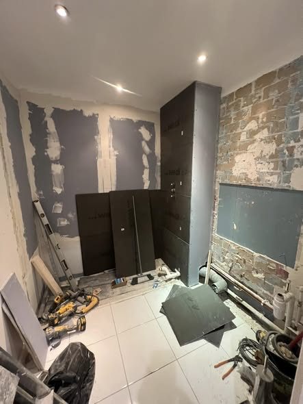The same bathroom stripped back to bare walls before the work started