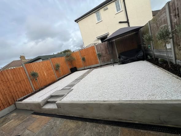 New timber fence with a gravel bed, stone steps and a patio